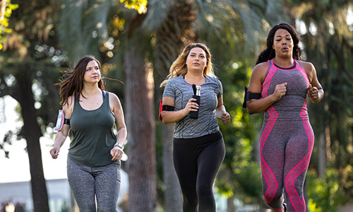 Three women running outside.